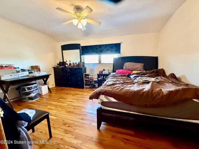 Bedroom featuring ceiling fan, lofted ceiling, and hardwood / wood-style floors | Image 5
