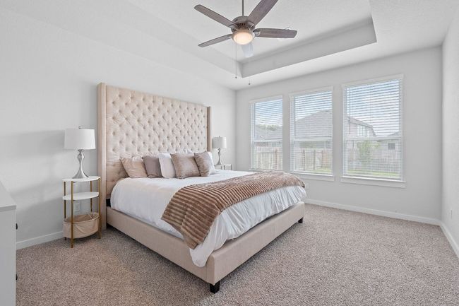 Bedroom with a raised ceiling, carpet floors, baseboards, and ceiling fan | Image 5