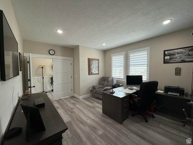 Home office featuring recessed lighting, baseboards, light wood-style floors, and a textured ceiling | Image 17