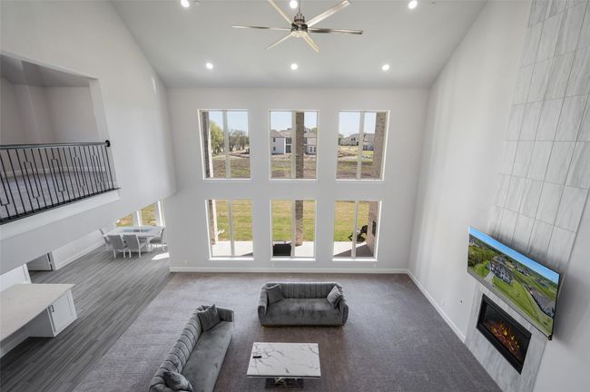 Living room featuring high vaulted ceiling, a glass covered fireplace, plenty of natural light, recessed lighting, and baseboards | Image 11