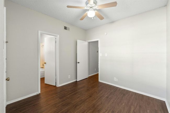 Unfurnished bedroom featuring baseboards, visible vents, a ceiling fan, a textured ceiling, and dark wood-type flooring | Image 18