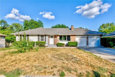 Single story home featuring a front yard and a garage | Image 1