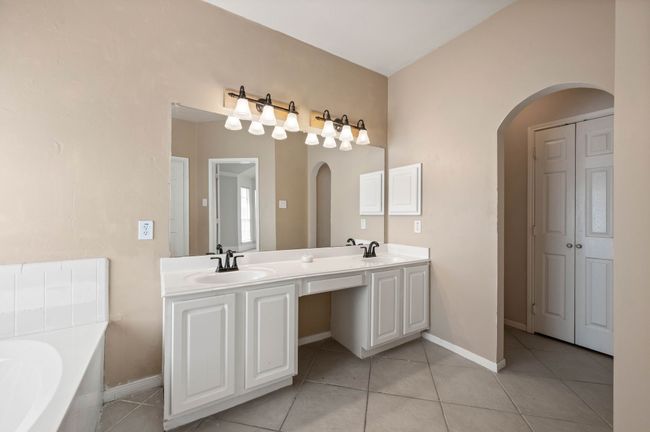 Full bath featuring tile patterned flooring, a sink, double vanity, and a bath | Image 22
