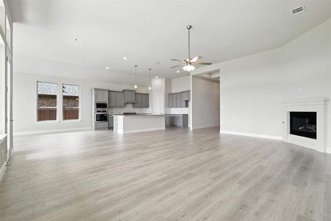 Unfurnished living room featuring ceiling fan, recessed lighting, a fireplace, and light wood-style flooring | Image 12