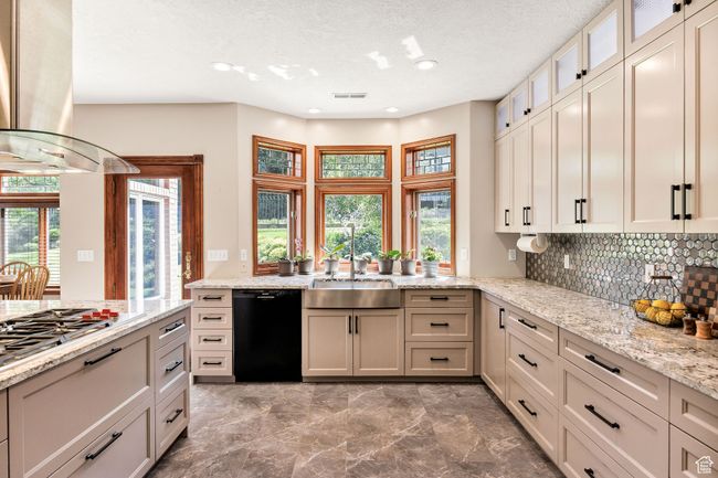Kitchen featuring dishwasher, island range hood, plenty of natural light, decorative backsplash, and recessed lighting | Image 4