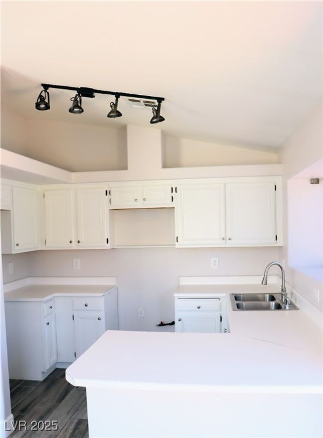 Kitchen with a sink, dark wood-style flooring, vaulted ceiling, and white cabinets | Image 5