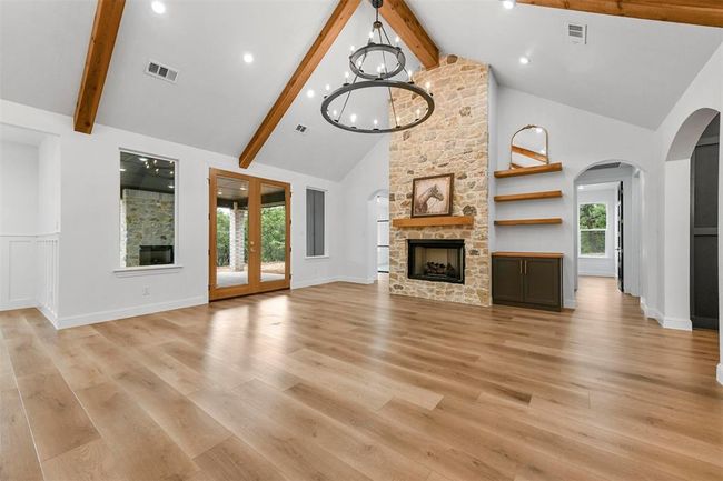 Unfurnished living room with high vaulted ceiling, light hardwood / wood-style flooring, and beamed ceiling | Image 6