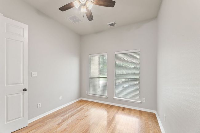 Empty room with ceiling fan and light wood-style floors | Image 19