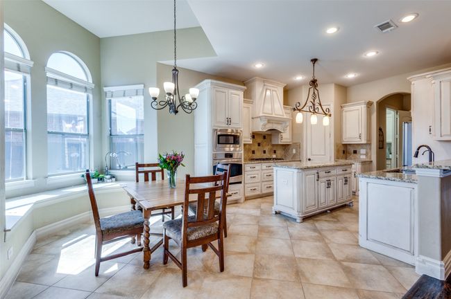 Kitchen with visible vents, custom range hood, appliances with stainless steel finishes, backsplash, and a chandelier | Image 13