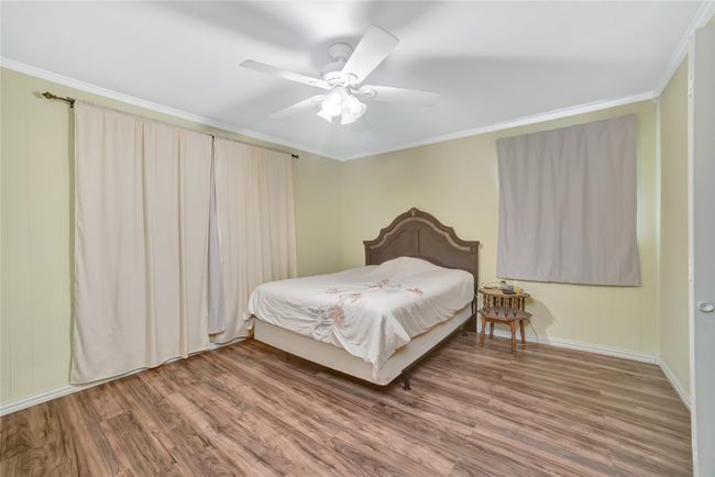 Bedroom with wood finished floors, crown molding, ceiling fan, and baseboards | Image 27