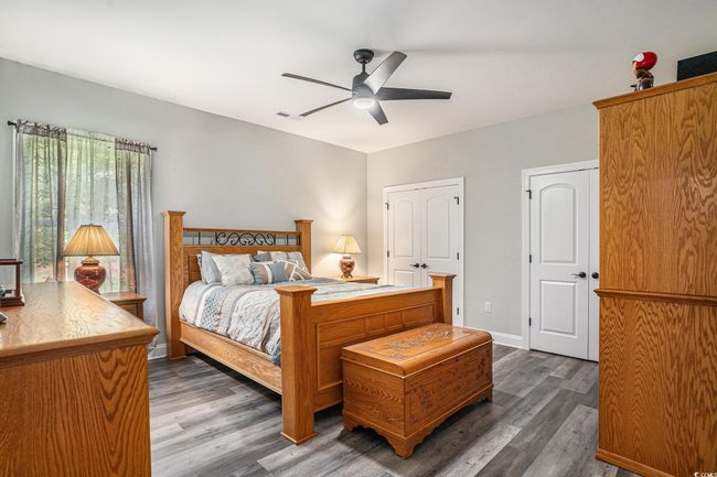 Bedroom featuring dark wood-type flooring, ceiling fan, and baseboards | Image 21