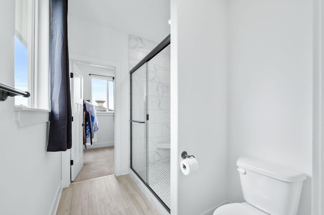Bathroom featuring a shower stall, toilet, wood finished floors, and baseboards | Image 18