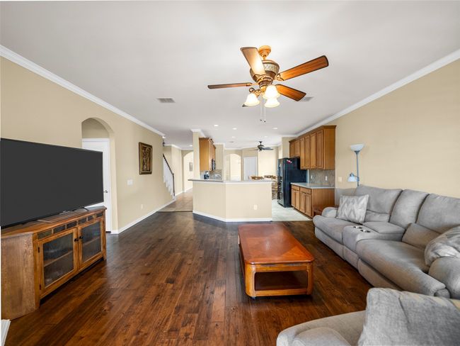 Living room featuring crown molding, visible vents, baseboards, and wood finished floors | Image 11