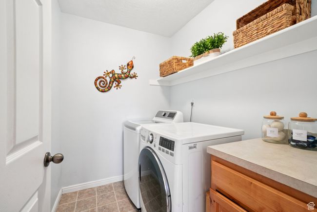 Laundry area featuring washing machine and clothes dryer and baseboards | Image 10
