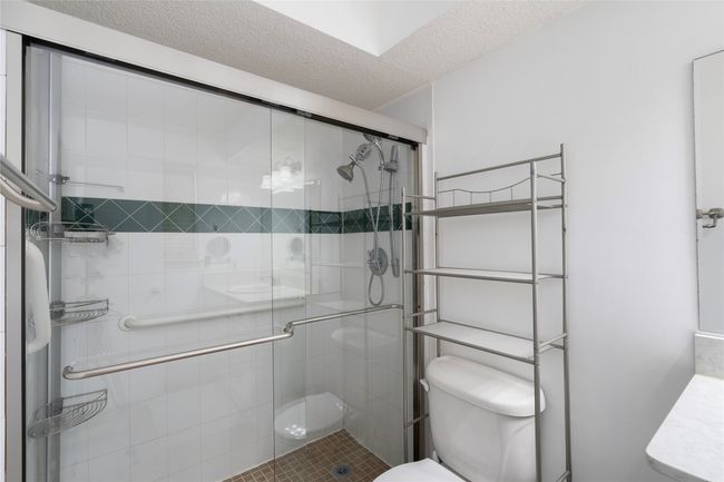 Bathroom with toilet, a shower stall, and a textured ceiling | Image 23