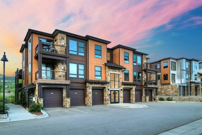 Multi unit property with driveway, a garage, a balcony, and stone siding | Image 34