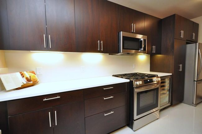 Fully renovated Eat-in-Kitchen has custom mocha colored cabinets, Quarts counters and stainless steel appliances including a wine cooler, dishwasher, microwave, range and refrigerator. | Image 8
