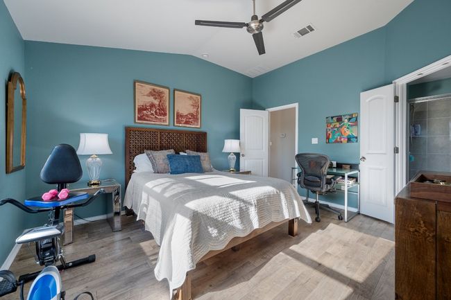 Bedroom featuring visible vents, baseboards, ceiling fan, vaulted ceiling, and wood finished floors | Image 10