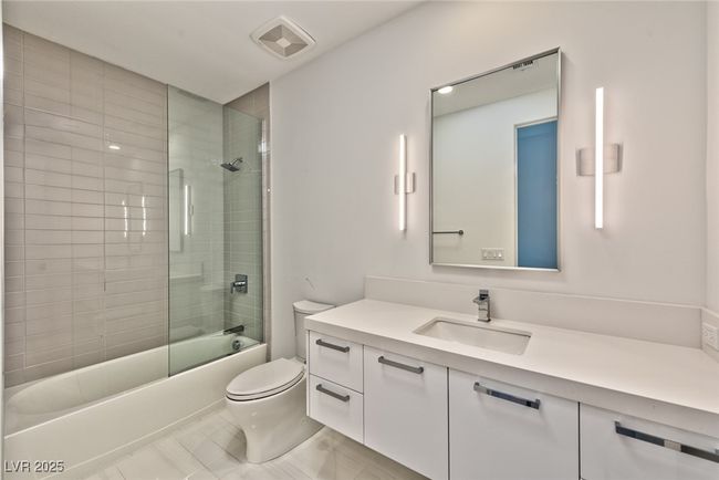 Bathroom featuring vanity, tile patterned flooring, visible vents, toilet, and bath / shower combo with glass door | Image 10