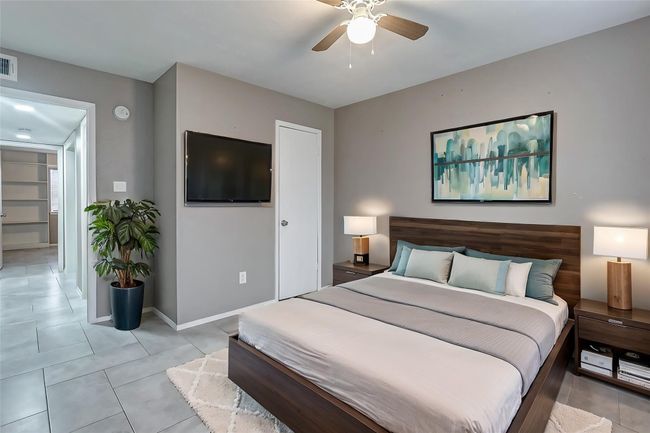 Another angle of the primary bedroom showcases its spacious layout and convenient access to the ensuite bathroom. The room’s open and modern design provides ample opportunity to create your ideal haven for relaxation. | Image 12