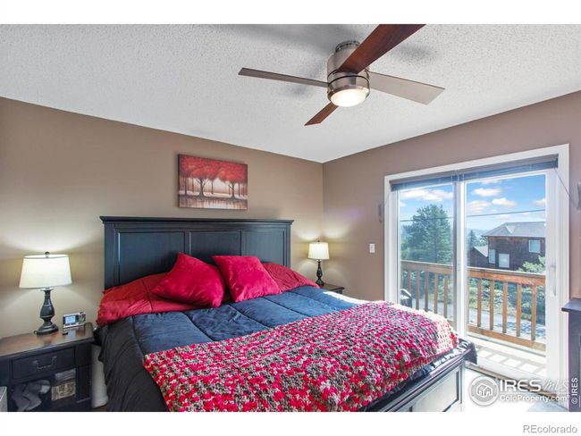 The upper level primary bedroom with access to its own balcony where you can enjoy views of The Lumpy Ridge. | Image 10