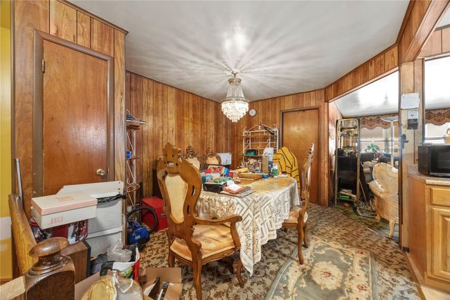 Dining area featuring wooden walls and a chandelier | Image 10