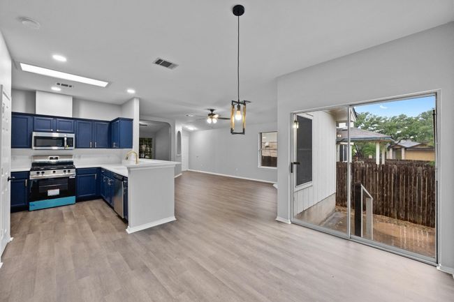 Kitchen featuring appliances with stainless steel finishes, blue cabinetry, a peninsula, ceiling fan, and light countertops | Image 10
