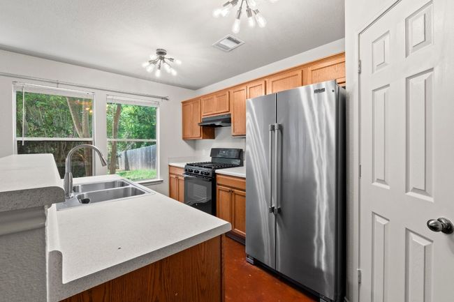 The kitchen boasts a bar, laminate countertops, and a pantry. | Image 10