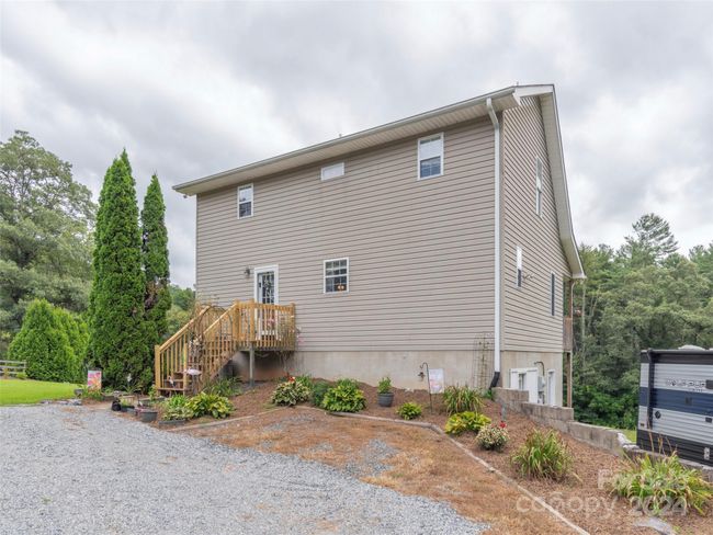Rear of home with abundant outdoor parking both for cars and an RV space. Inviting garden spaces with annuals/perennials. | Image 23