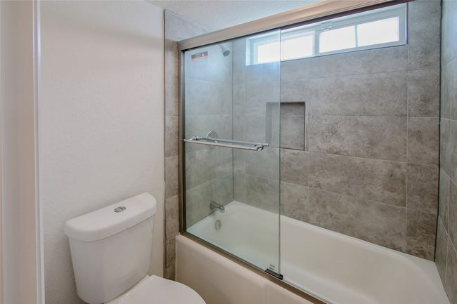 Bathroom with toilet and combined bath / shower with glass door | Image 20