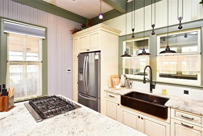 The gas stove has a slide up vent that downdrafts to keep the open kitchen look. | Image 13