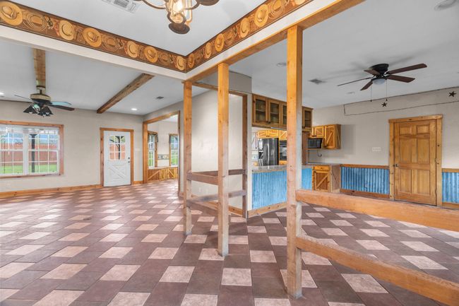 Empty room with beamed ceiling, baseboards, a ceiling fan, and visible vents | Image 10