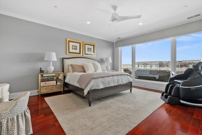 Bedroom featuring visible vents, crown molding, baseboards, ceiling fan, and dark wood-type flooring | Image 10