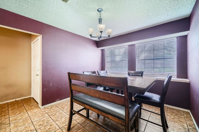 Dining room featuring a chandelier, a textured ceiling, and tile patterned floors | Image 9