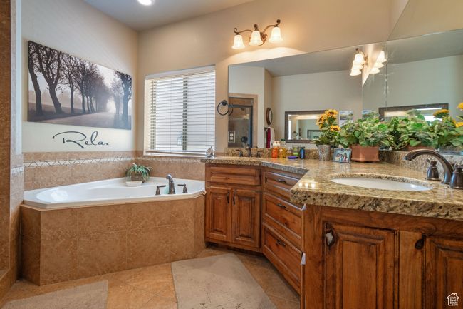 Full bathroom with tile patterned flooring, double vanity, and a garden tub | Image 16