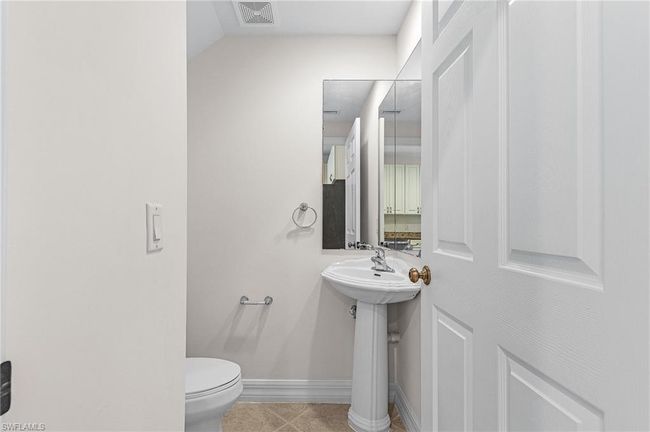 Half bathroom with toilet and tile patterned floors | Image 9