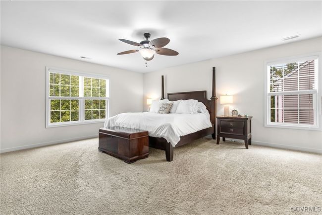 Primary bedroom with neutral carpet, ceiling fan and en suite bath | Image 21