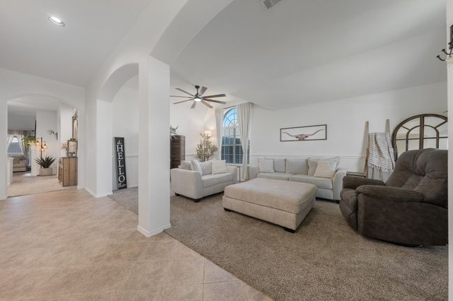 Living room featuring a ceiling fan, arched walkways, light tile patterned flooring, and recessed lighting | Image 9