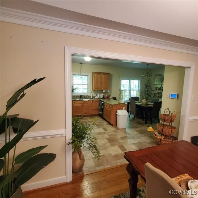 Dining space with an inviting chandelier, light wood-style flooring, and ornamental molding | Image 16
