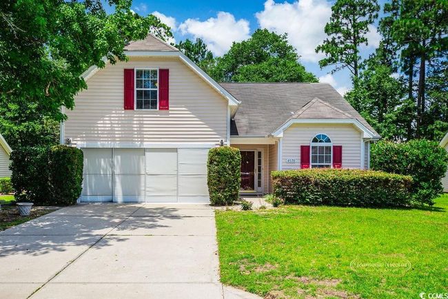 Traditional-style house with a front lawn, concrete driveway, and roof with shingles | Image 5