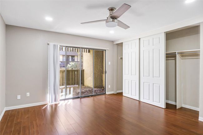 Unfurnished bedroom featuring wood finished floors, access to exterior, recessed lighting, baseboards, and ceiling fan | Image 7