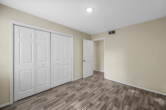 Unfurnished bedroom featuring wood finished floors, a closet, and recessed lighting | Image 7