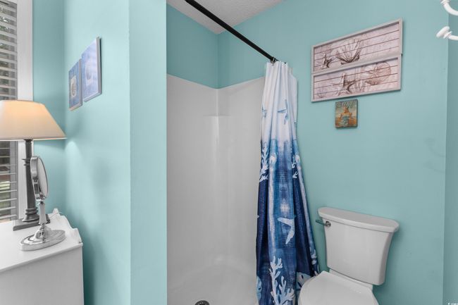 Full bathroom with toilet, a shower stall, and a textured ceiling | Image 18