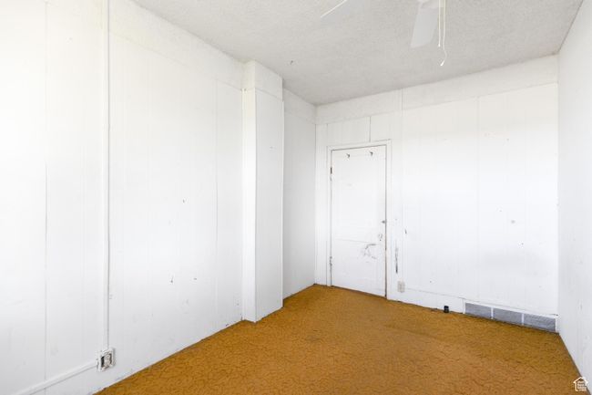 Empty room with a ceiling fan, carpet, and visible vents | Image 10