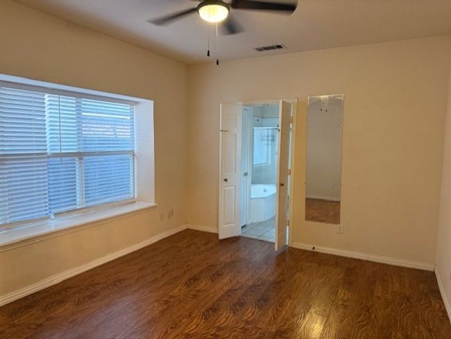Empty room with wood finished floors, healthy amount of natural light, and a ceiling fan | Image 12