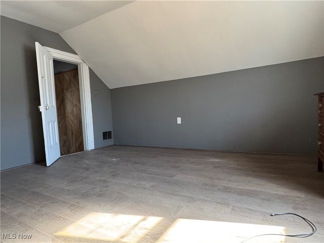 Additional living space with visible vents, vaulted ceiling, and wood finished floors | Image 26
