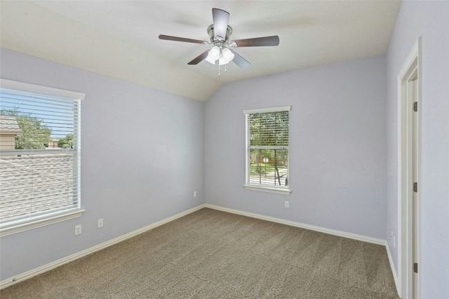 Carpeted empty room featuring healthy amount of natural light, baseboards, and lofted ceiling | Image 24
