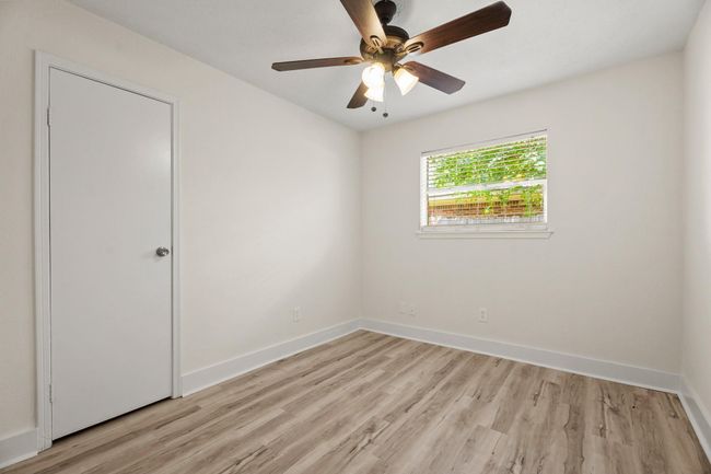 One of two secondary bedrooms- new fan, new floors, fresh paint, and a walk in closet! | Image 10