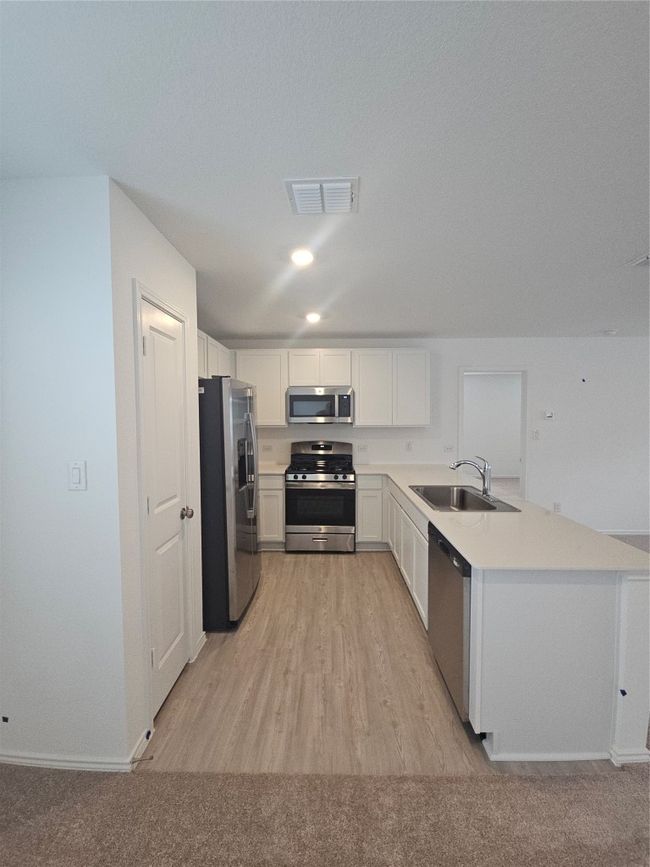 Kitchen with stove, fridge, a sink, dishwasher, and a peninsula | Image 17