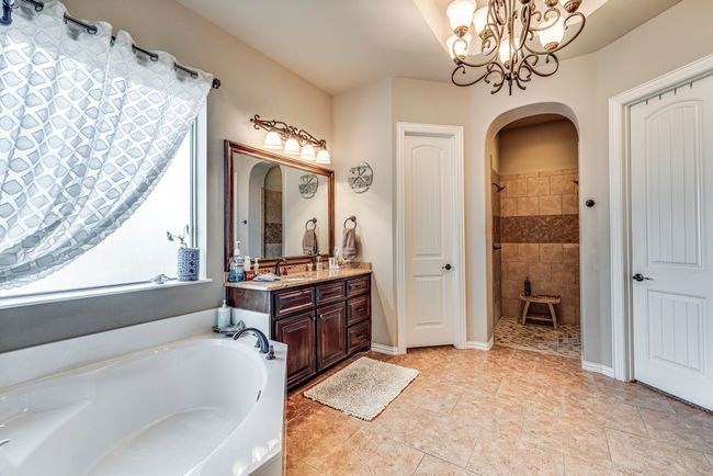 Primary bathroom featuring vanity, tile patterned flooring, plus walk in shower, and a notable chandelier | Image 4